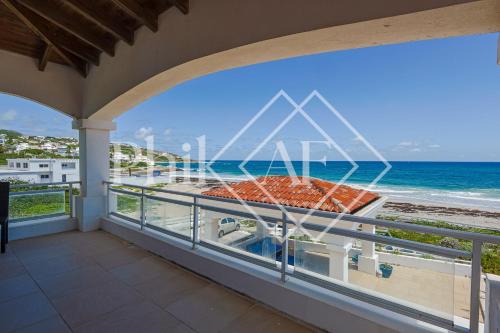 a balcony with a view of the ocean at 10 bed-rooms luxury BEACH VILLA in Guana Bay