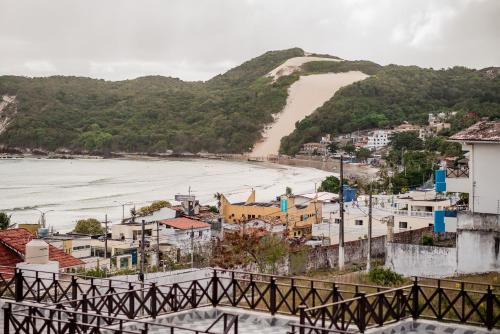a view of a beach with houses and a bridge at Apart Hotel Serantes in Natal