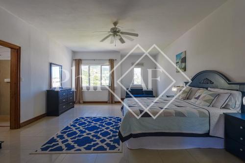 a bedroom with a bed and a ceiling fan at 10 bed-rooms luxury BEACH VILLA in Guana Bay