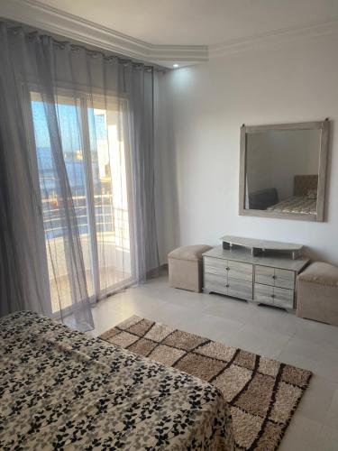 a hotel room with a bed and a mirror at Duplex El mansoura A3 in Kelibia