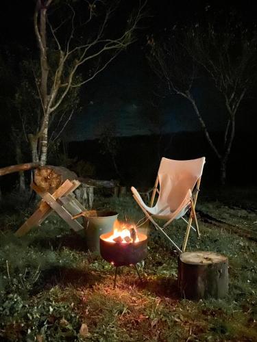 a chair and a fire in a yard at night at kakayama hutte in Muraoka
