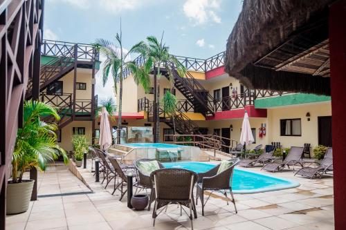 une piscine avec des chaises et une table ainsi qu'un bâtiment dans l'établissement Apart Hotel Serantes, à Natal