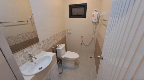 een badkamer met een toilet, een wastafel en een douche bij Hatyai.Muslim.Home in Hat Yai