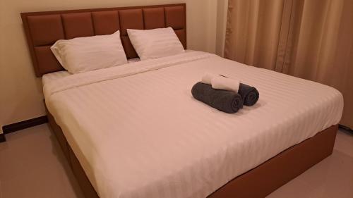a bedroom with a bed with two towels on it at Hatyai.Muslim.Home in Hat Yai