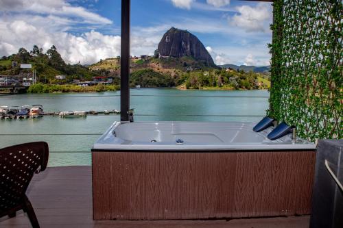 a bath tub in a room with a view of a lake at Marina Navegar in Guatapé
