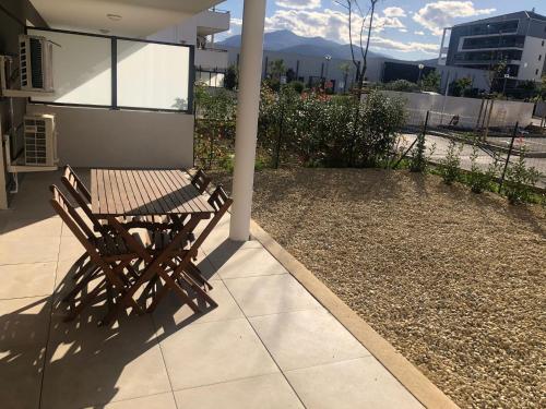 un banco de madera sentado en el porche de una casa en L'albizia Studio calme et tout confort en Lucciana