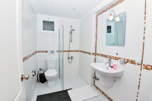 a bathroom with a shower toilet and a sink at The Royal Links two bedroom apartment in Ortaca