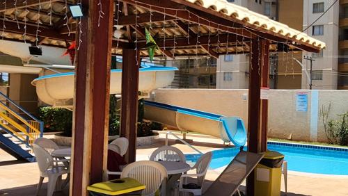 a pool with a slide and chairs and a boat at Prive das Thermas - 301B in Caldas Novas