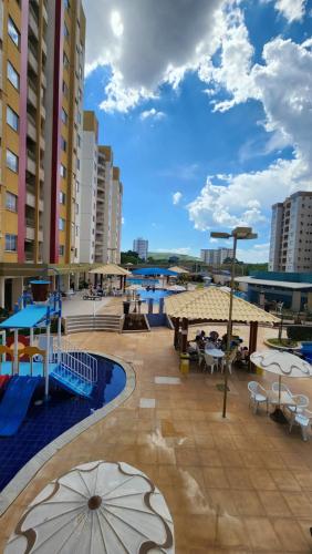 a patio with tables and umbrellas in a resort at Prive das Thermas - 301B in Caldas Novas