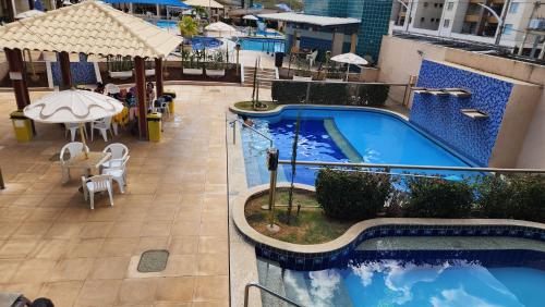 a pool on the side of a building with a table at Prive das Thermas - 301B in Caldas Novas