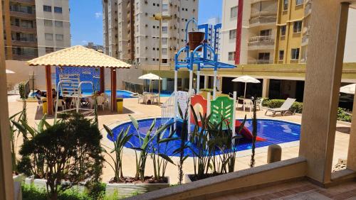 a pool with a slide and a playground with buildings at Prive das Thermas - 301B in Caldas Novas