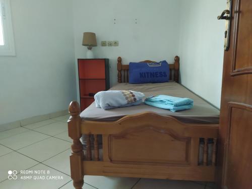 a small bed with two blue pillows on it at Chambre dans un appartement ensoleillé in Tangier