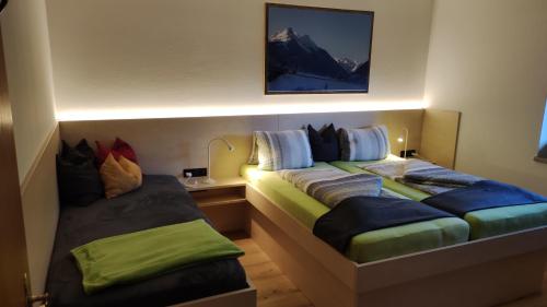 1 dormitorio con 2 camas y mesita de noche con en Appartements Gerhard, en Telfes im Stubai