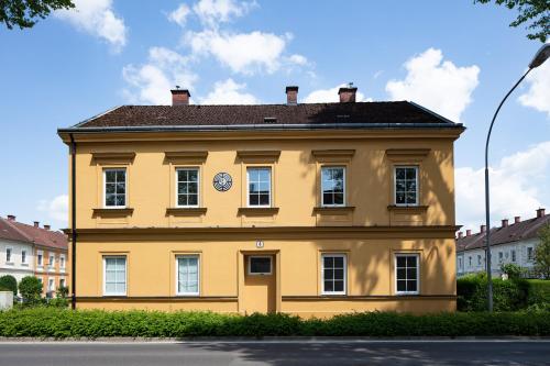 un edificio amarillo con un reloj a un lado en Stilvoll Wohnen im Herzen der Stadt, en Steyr