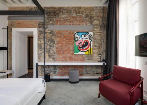 a bedroom with a brick wall and a bed and a chair at BURSA Hotel Kyiv in Kyiv