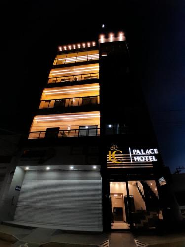 a tall building with a sign on it at night at LC Palace Hotel in Capim Grosso