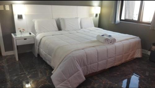 a bedroom with a large bed with towels on it at Golden Flat's - Slaviero Guarulhos in Guarulhos