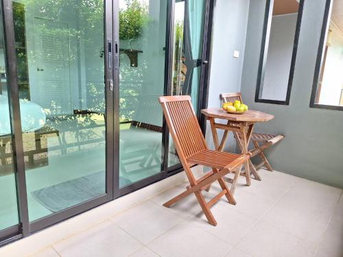 a table and chairs on a balcony with a table and fruit at Lanta noblesse in Ko Lanta