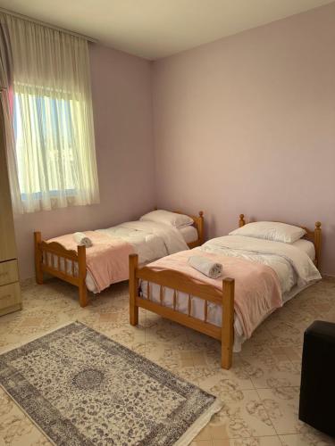 a room with two beds and a window and a rug at Hostel Rinas in Rinas