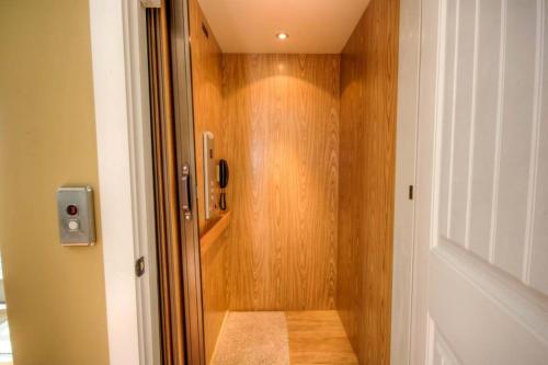 a bathroom with a shower with a wooden wall at Luxury Townhouse w/ Golf Cart & Private Elevator in Carolina Beach
