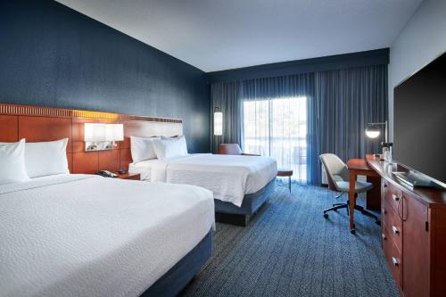 a hotel room with two beds and a desk at Courtyard Chicago Highland Park/Northbrook in Highland Park