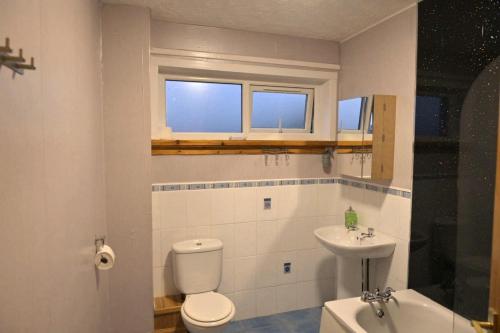 a bathroom with a toilet and a sink at Take A Break and Unwind At This Peaceful Home in Saltcoats