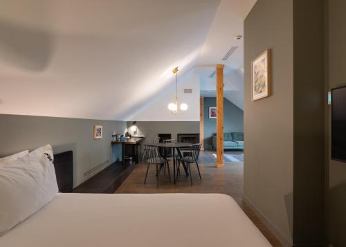 a bedroom with a bed and a dining room at BURSA Hotel Kyiv in Kyiv