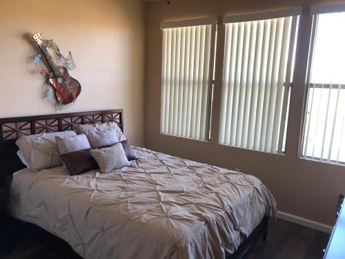 een slaapkamer met een bed met een gitaar aan de muur bij 5 Star Resort Living Grayhawk Scottsdale in Scottsdale