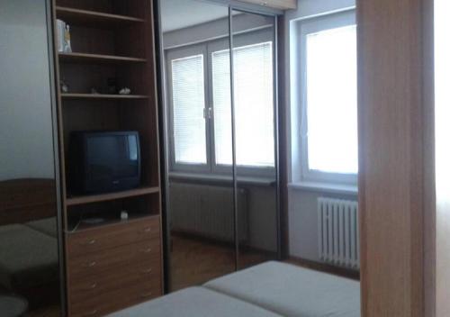 um quarto com um espelho e uma televisão num quarto em Apartmán v centre Žiliny em Žilina