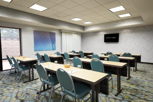 a conference room with tables and chairs and a screen at SpringHill Suites St. Louis Brentwood in Brentwood
