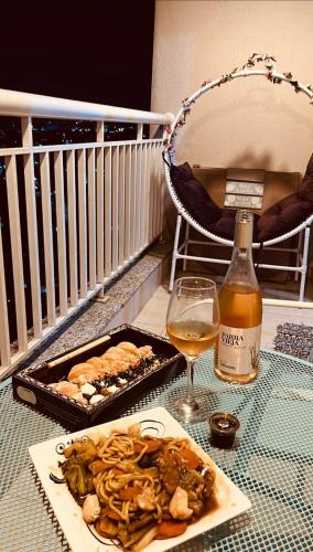 a table with a plate of food and a bottle of wine at Terraço Harmony Flats GRU in Guarulhos