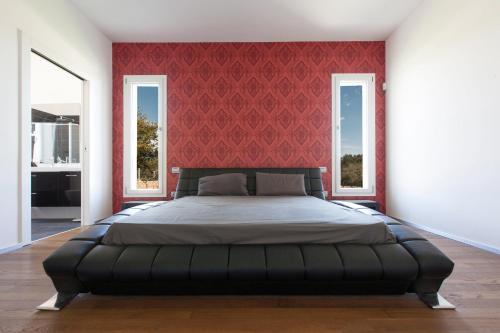 ルッファーノにあるVilla Daiana by Perle di Pugliaの赤い壁のベッドルーム1室(大型ベッド1台付)