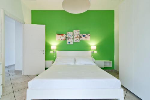 ein Schlafzimmer mit einem weißen Bett und einer grünen Wand in der Unterkunft Casa Arditi - Lecce Selection in Lecce