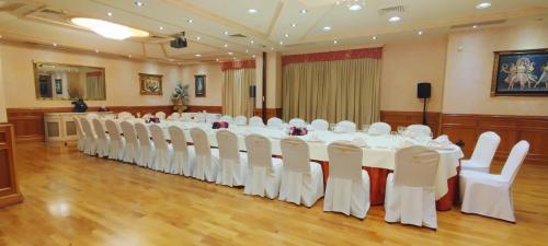 a conference room with a long table and white chairs at Hotel Conde Ansúrez in Valladolid