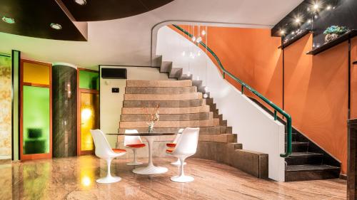 a stairway with three chairs and a table and stairs at La Gigasuite - Design Villa at Sea with Spa & Pool in Taranto