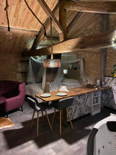 a bedroom with a desk and a bed and a table at L'écrin Dasna in Bourg-sur-Gironde