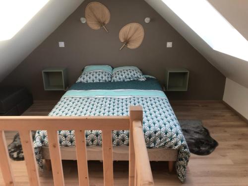 a bedroom with a bed in the attic at La petite maison in Putanges