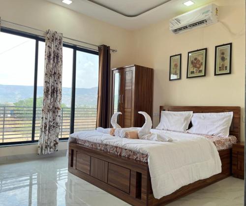 a bedroom with a large bed with a large window at Paradise Villa with pool table and big garden in Lonavala