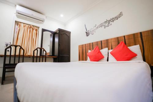 1 dormitorio con 1 cama grande con almohadas rojas en Hotel BNB, en Pondicherry