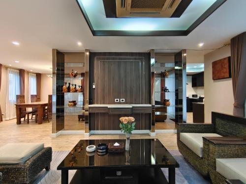 a living room with a couch and a table at Baan Natcha Pool Villa City Center in Pattaya