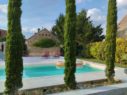 a pool with trees in front of a house at Maison à proximité du village de George Sand in Nohant-Vic
