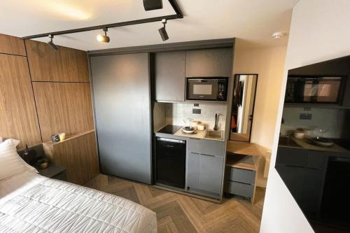 Habitación pequeña con cama y cocina en Deluxe 1 Bed Studio 4A near Royal Infirmary & DMU en Leicester