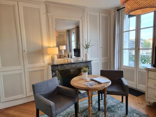 - un salon avec une table, des chaises et un miroir dans l'établissement Le Balcon du Port, à Honfleur
