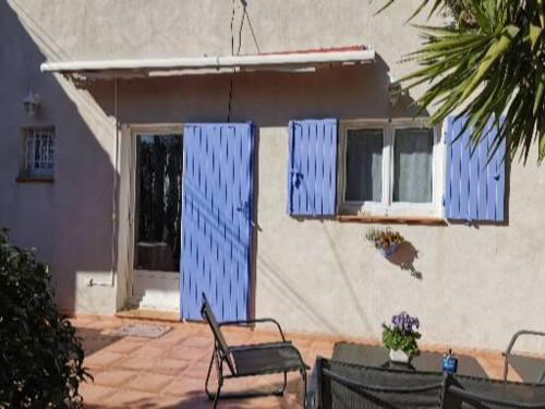 una casa con puertas azules, mesa y sillas en Le petit havre de Paix, en Toulon