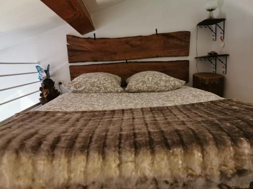 1 dormitorio con 1 cama grande con cabecero de madera y almohadas en Le petit havre de Paix, en Toulon