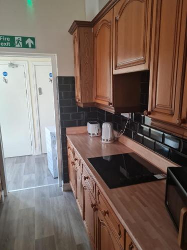 a kitchen with wooden cabinets and a counter top at Brighton Rd in Derby