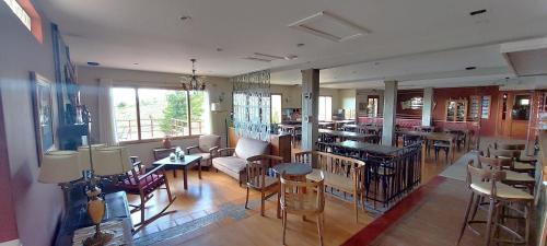a restaurant with tables and chairs in a room at Meulen Hosteria y Apart in El Calafate