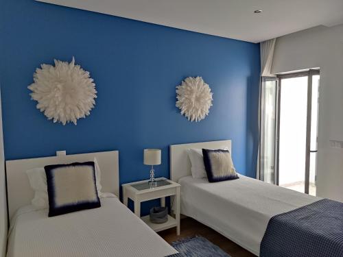 2 Betten in einem Zimmer mit blauen Wänden in der Unterkunft The Old Town House in Faro