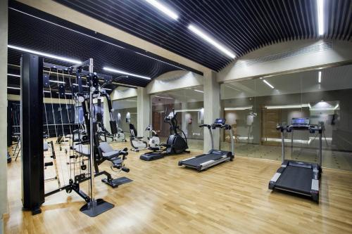 a gym with a bunch of treadmills and ellipticals at Porto Palace Hotel Thessaloniki in Thessaloniki