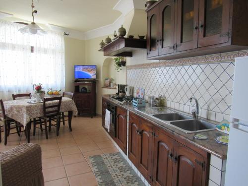 una cucina con lavandino e tavolo in una stanza di Casa Vacanze Il Libeccio a Positano